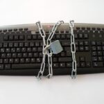 키보드를 체인과 자물쇠로 묶어 둔 모습. 미신고 가상자산 사이트 접속차단 자료사진